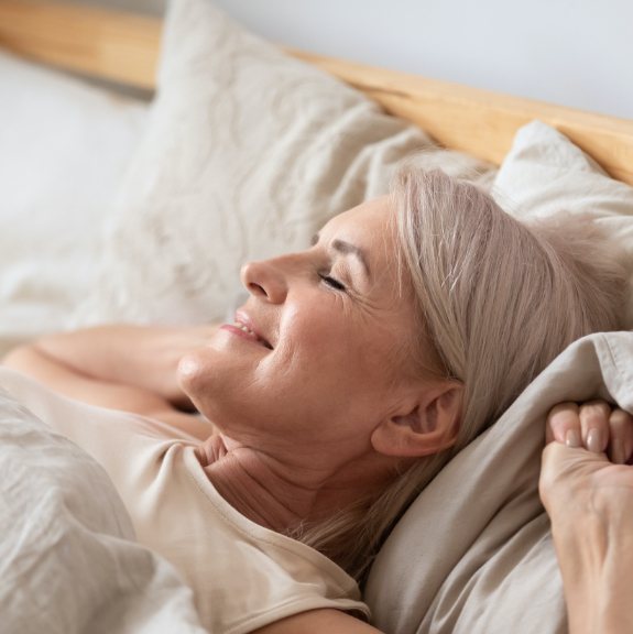Woman waking feeling rested thanks to sleep apnea treatment