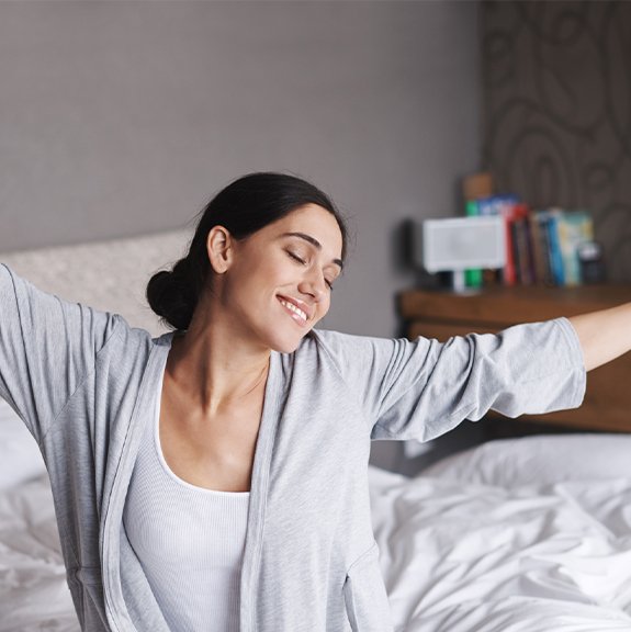 Woman waking feeling rested thanks to sleep apnea therapy
