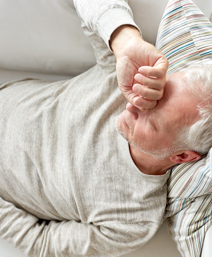 Very tired senior man resting on sofa