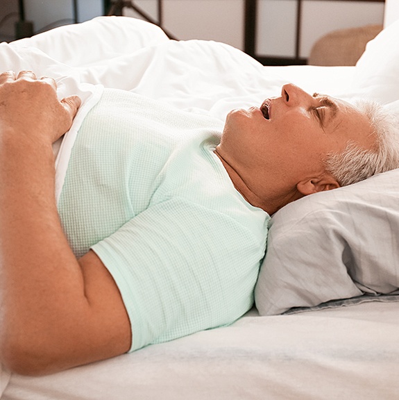 Snoring senior man lying in bed