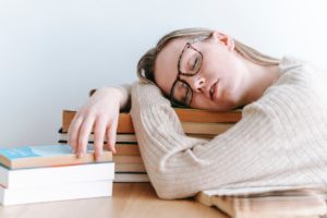 Woman napping on stack of books