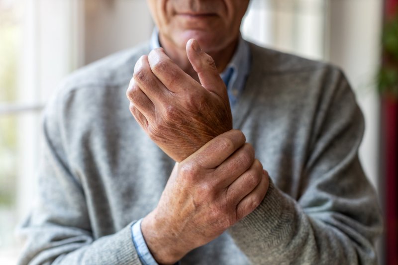 An arthritic man rubbing his hands