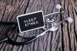 Stethoscope around tiny chalkboard that says “sleep apnea”
