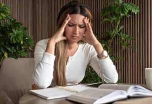 Woman sitting at desk, struggling to concentrate