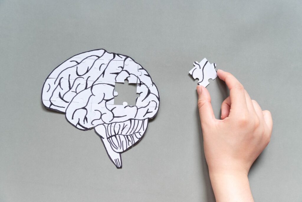 A hand completing a brain shaped puzzle