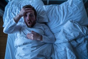 Man waking up from nightmare.